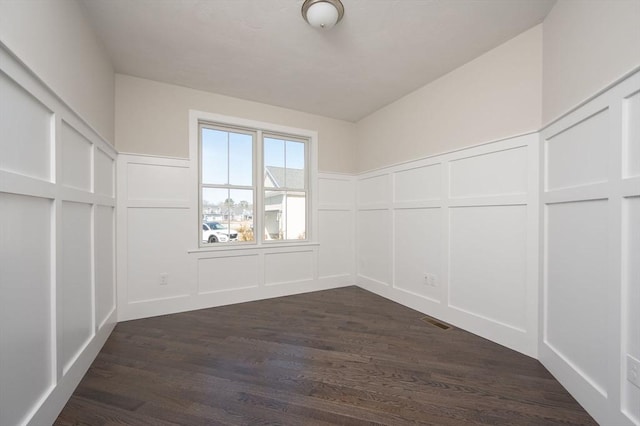 unfurnished room with dark wood-type flooring