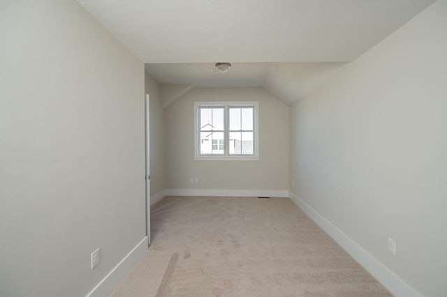 bonus room featuring light colored carpet and vaulted ceiling