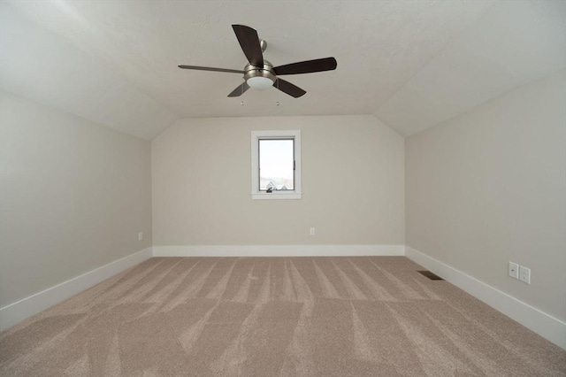 additional living space featuring light colored carpet, vaulted ceiling, and ceiling fan