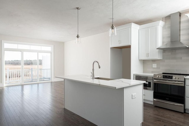 kitchen featuring a kitchen island with sink, wall chimney exhaust hood, decorative light fixtures, and stainless steel range with electric stovetop