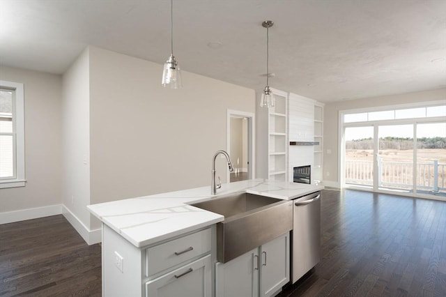 kitchen featuring light stone countertops, hanging light fixtures, dark hardwood / wood-style flooring, a kitchen island with sink, and white cabinets