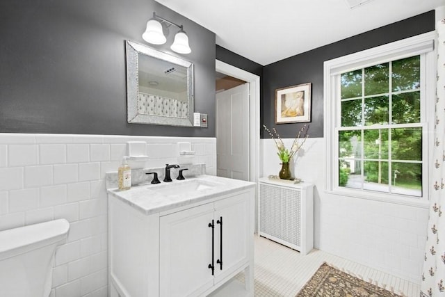 38 S St, Grafton, MA 01519 - full bath featuring tile walls, vanity, plenty of natural light, radiator heating unit, and tile patterned flooring