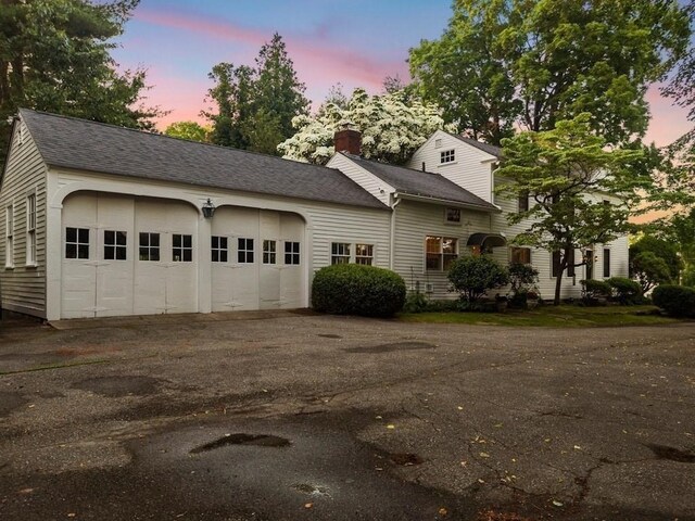 38 S St, Grafton, MA 01519 - view of front of home with driveway, a chimney, a garage, and roof with shingles