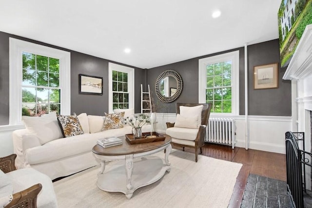 38 S St, Grafton, MA 01519 - living area with radiator, dark wood-style flooring, a wainscoted wall, recessed lighting, and a fireplace with flush hearth