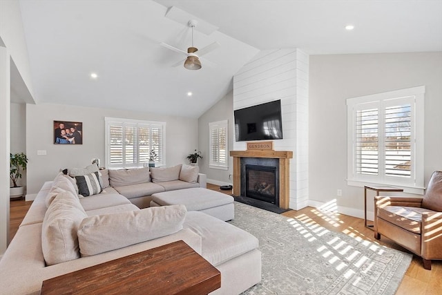 living room featuring vaulted ceiling, light hardwood / wood-style floors, and ceiling fan