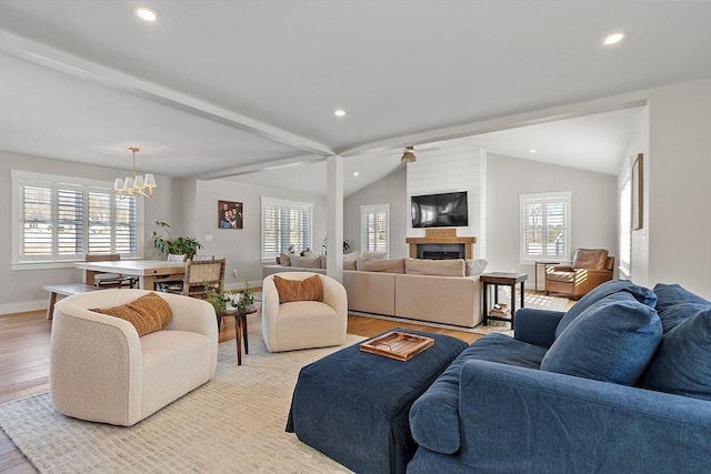 living room with lofted ceiling with beams, ceiling fan with notable chandelier, and light hardwood / wood-style floors