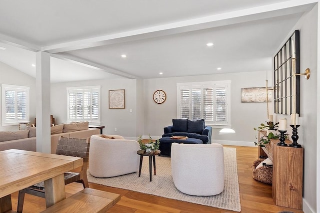 living room featuring vaulted ceiling with beams and light wood-type flooring