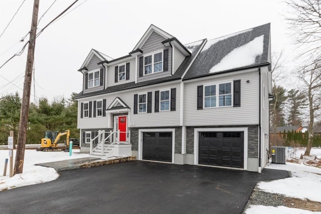 view of front facade featuring a garage and central AC