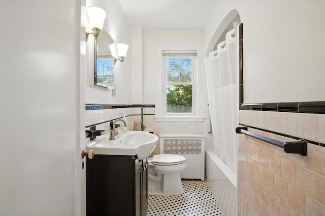 182 Winn St, Woburn, MA 01801 - bathroom featuring radiator, tile walls, vanity, wainscoting, and shower / tub combo with curtain