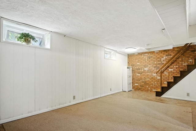 182 Winn St, Woburn, MA 01801 - below grade area featuring carpet flooring, a textured ceiling, stairs, and brick wall