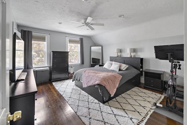 bedroom featuring lofted ceiling, a textured ceiling, wood finished floors, and ceiling fan