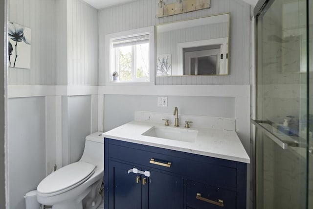 full bath with toilet, vanity, and a stall shower