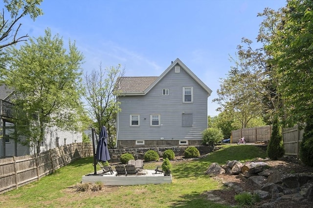 back of property with a patio area and a shingled roof