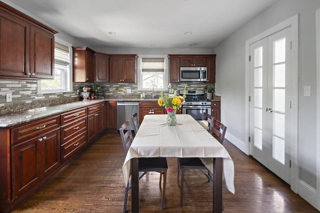 kitchen featuring stainless steel appliances, decorative backsplash, dark wood-type flooring, a sink, and recessed lighting