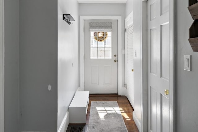 entryway with dark wood-type flooring and baseboards
