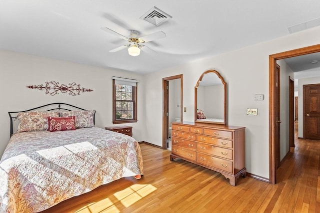 bedroom with baseboards, visible vents, ceiling fan, and light wood finished floors