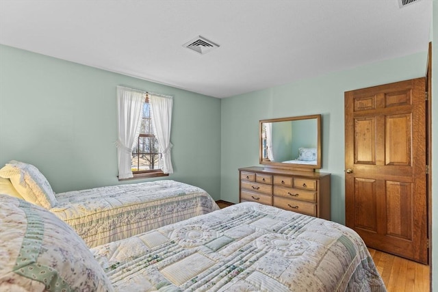 bedroom with wood finished floors and visible vents