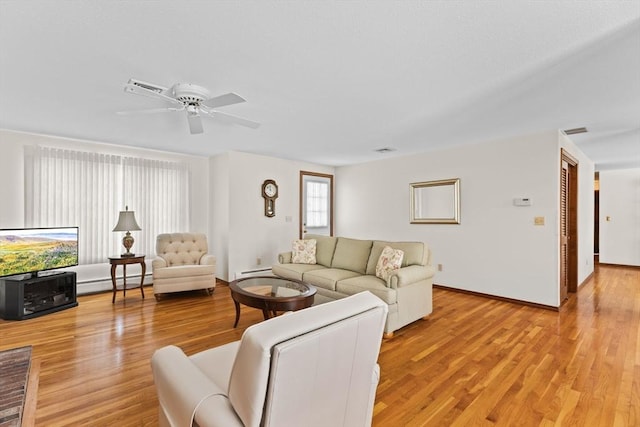 living area with light wood finished floors, baseboard heating, and visible vents