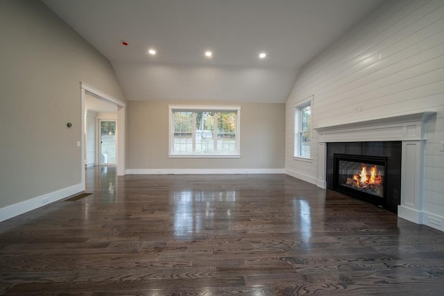 unfurnished living room with a tile fireplace, dark hardwood / wood-style floors, and lofted ceiling