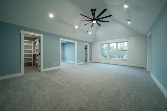 interior space featuring light colored carpet, ceiling fan, a spacious closet, a closet, and lofted ceiling