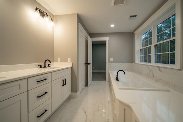 bathroom featuring vanity and a relaxing tiled tub