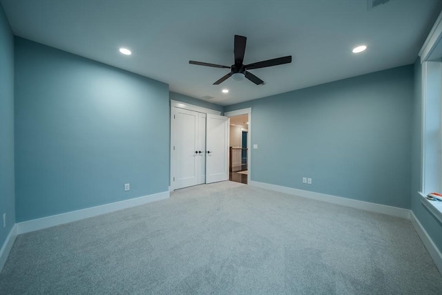 unfurnished bedroom with ceiling fan, light colored carpet, and a closet