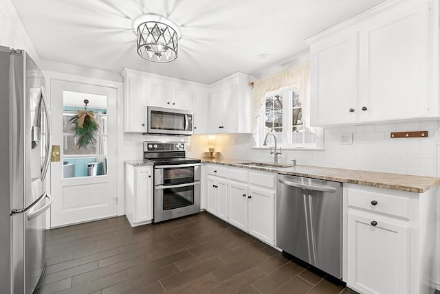 kitchen featuring backsplash, sink, white cabinets, and appliances with stainless steel finishes