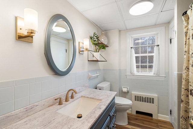 bathroom with radiator heating unit, vanity, hardwood / wood-style floors, and toilet