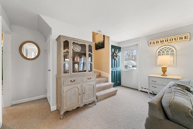 living area featuring light carpet and a baseboard heating unit