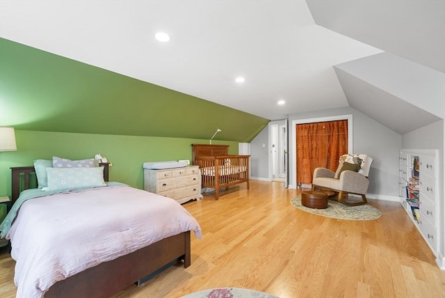 bedroom featuring light hardwood / wood-style floors and vaulted ceiling