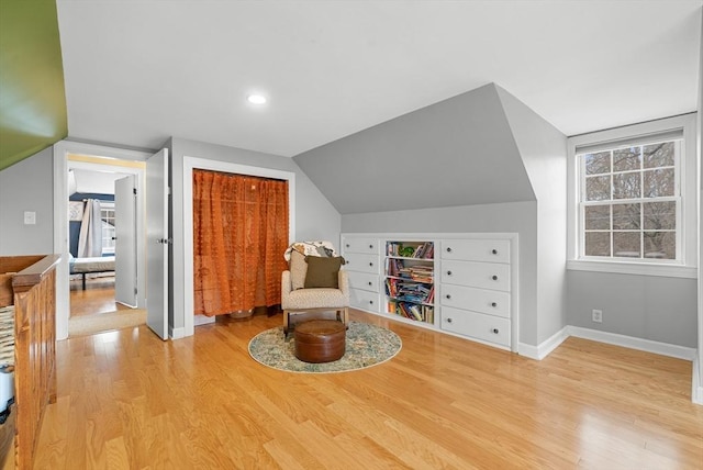 sitting room with lofted ceiling and light wood-type flooring