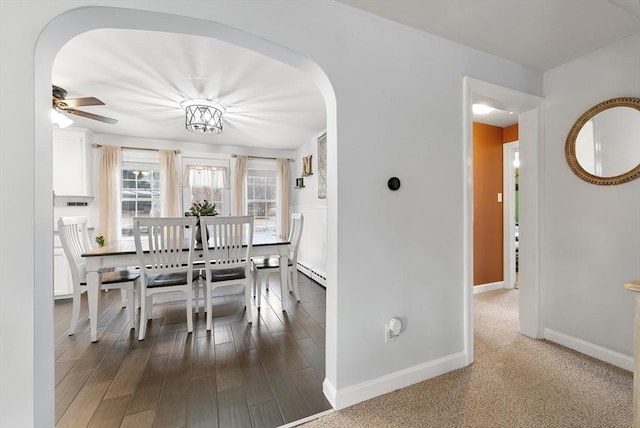 dining room featuring hardwood / wood-style flooring, ceiling fan, and a baseboard heating unit