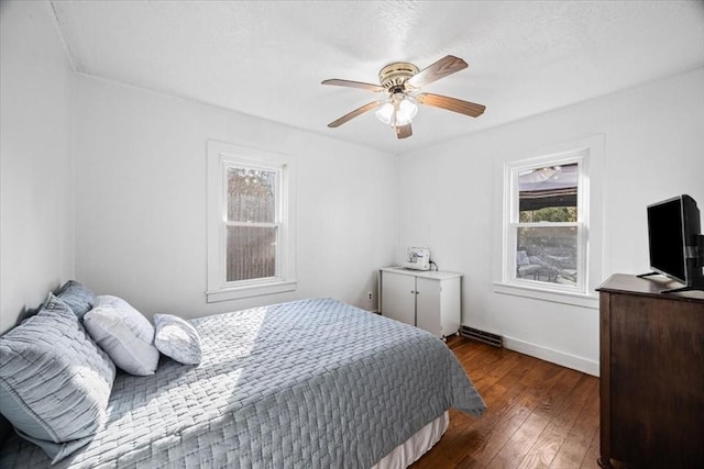 bedroom featuring dark wood-style floors, a textured ceiling, a ceiling fan, and baseboards