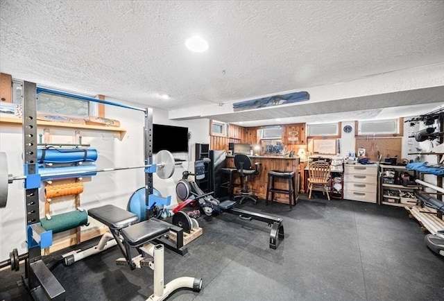 workout area featuring a textured ceiling and a bar