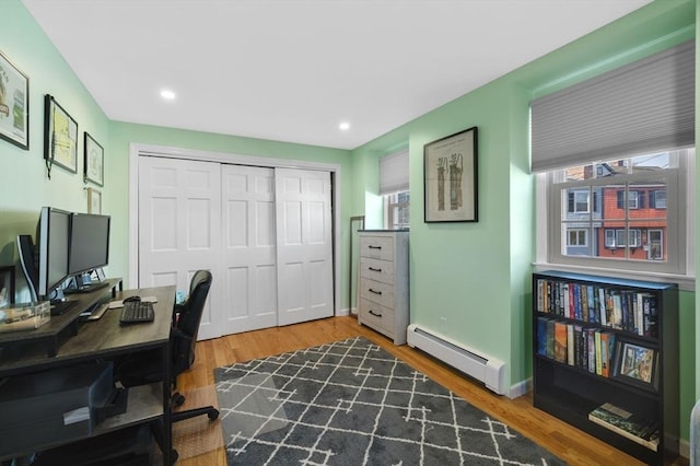 office area featuring hardwood / wood-style floors and a baseboard heating unit