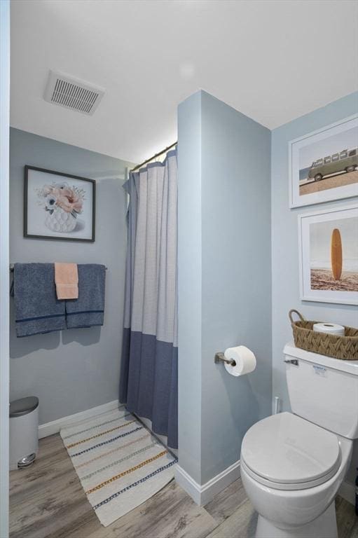 bathroom featuring a shower with curtain, toilet, and hardwood / wood-style flooring