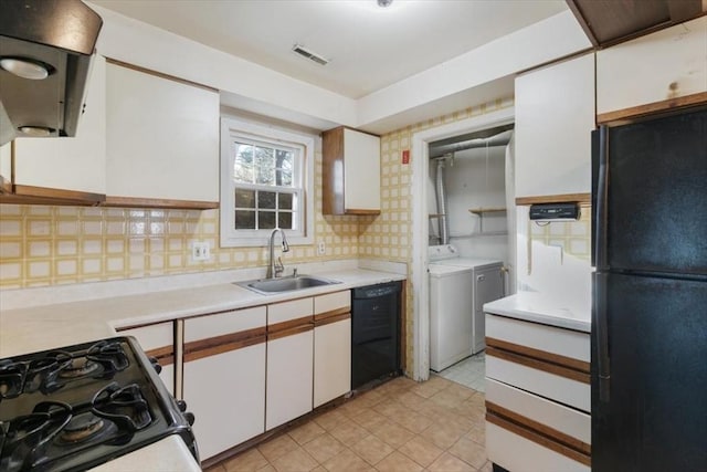 kitchen featuring white cabinets, sink, separate washer and dryer, and black appliances