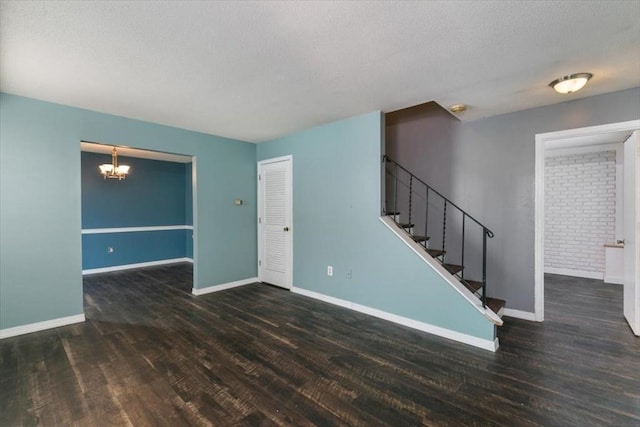 unfurnished room featuring a chandelier and dark hardwood / wood-style floors