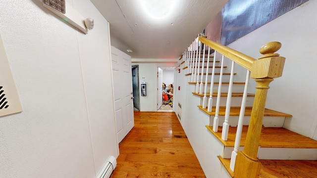 hallway with light hardwood / wood-style floors and baseboard heating