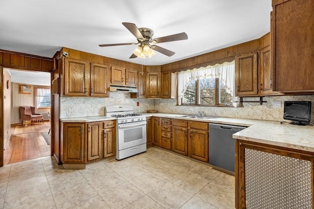 kitchen featuring sink, ceiling fan, decorative backsplash, stainless steel dishwasher, and white gas stove