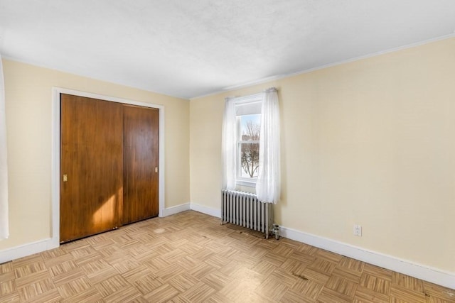 unfurnished bedroom with light parquet floors and radiator