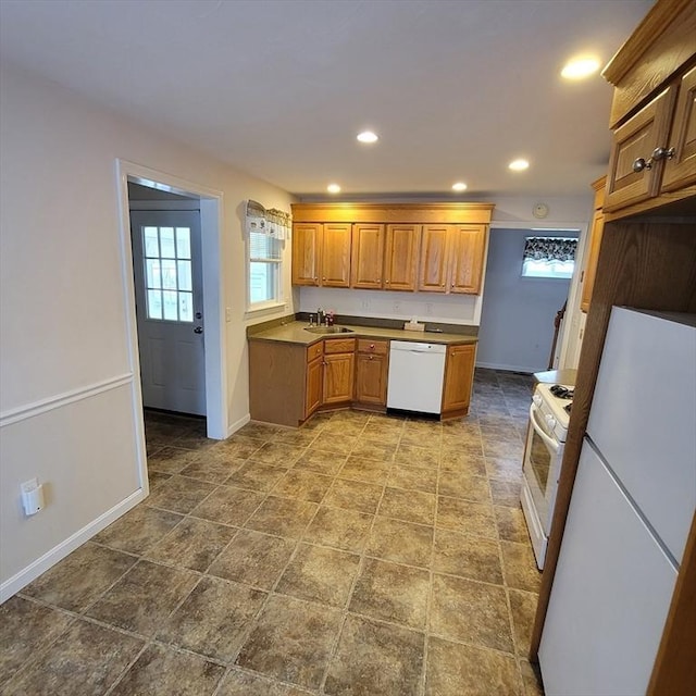 kitchen with plenty of natural light, white appliances, and sink