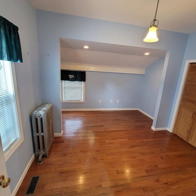 interior space with radiator heating unit and hardwood / wood-style floors