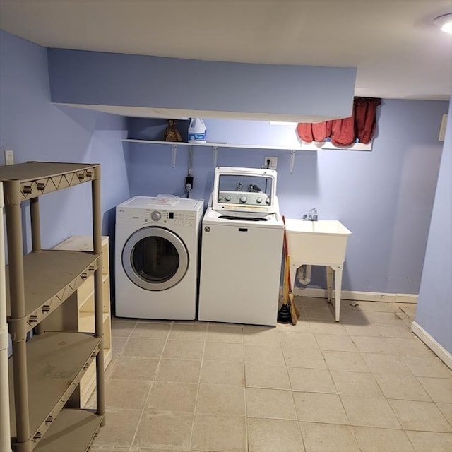 laundry room with light tile patterned floors and washer and clothes dryer