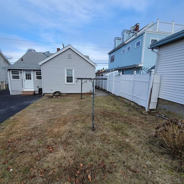 back of property with a yard and central AC unit