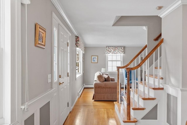 entrance foyer featuring crown molding, a baseboard radiator, and light wood-type flooring