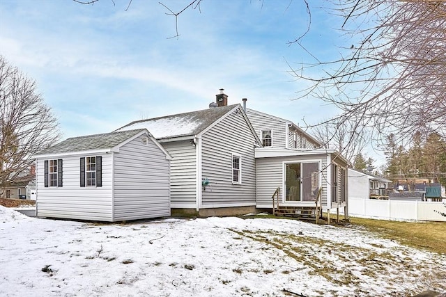 view of snow covered rear of property