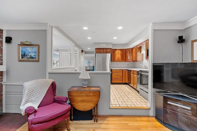 kitchen featuring stainless steel appliances, sink, and light hardwood / wood-style floors