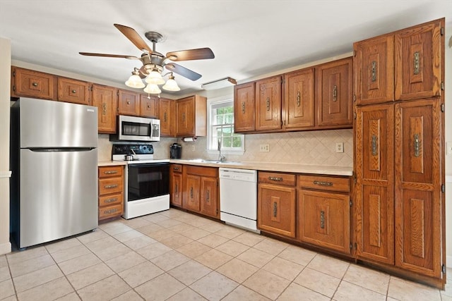 112 Stoddard Dr, North Attleboro, MA 02760 - kitchen featuring appliances with stainless steel finishes, brown cabinets, light countertops, and tasteful backsplash