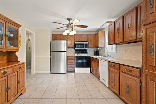 112 Stoddard Dr, North Attleboro, MA 02760 - kitchen featuring appliances with stainless steel finishes, a sink, brown cabinetry, backsplash, and a ceiling fan